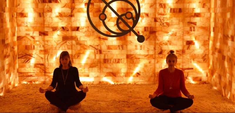People meditating next to the salt wall at Quasar Quantum Healing