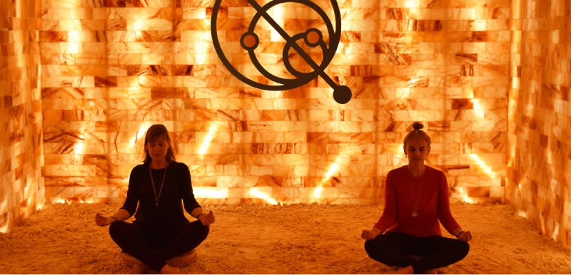 People meditating next to the salt wall at Quasar Quantum Healing